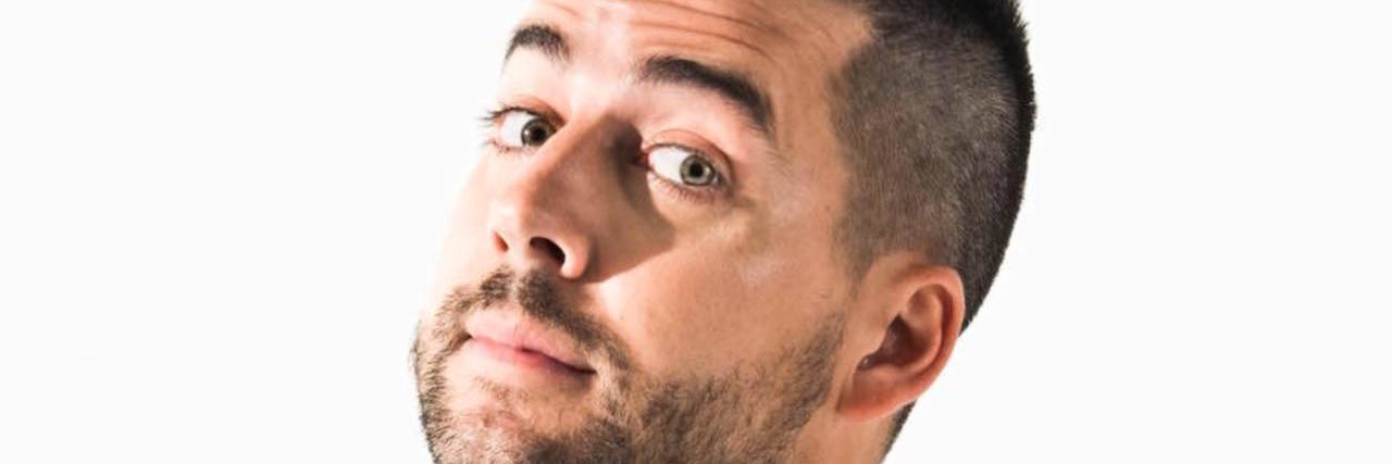 Comedian John Crist's Jokes Miss the Mark on Disability and the Church A photo of comedian John Crist standing in front of a white backdrop and microphone.