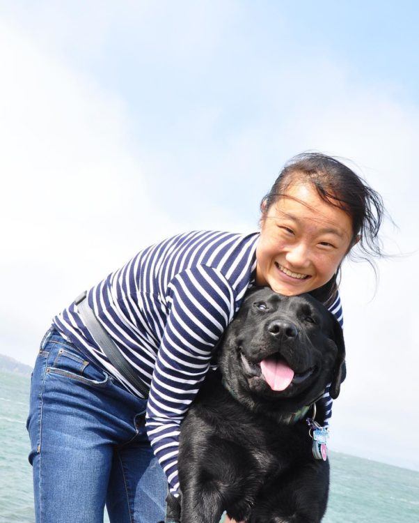 The author and her service dog, at the beach. The dog is a black lap