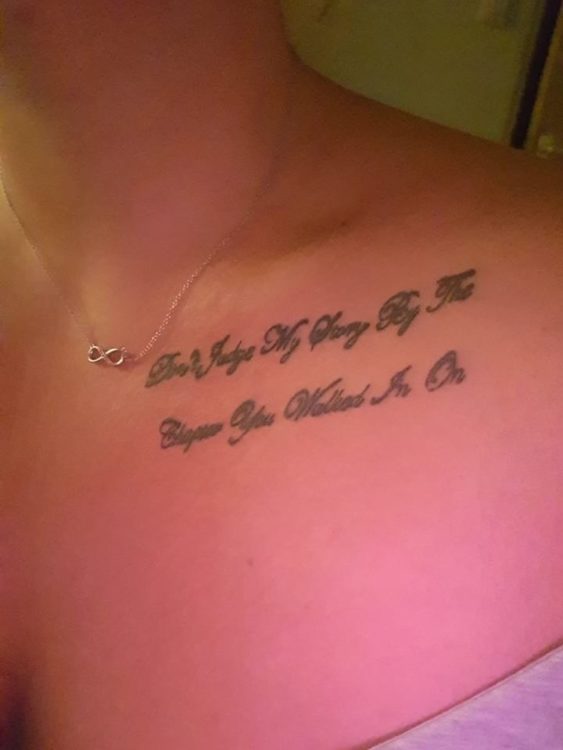 A tattoo on a woman's chest that reads in cursive: "Don't judge my story by the chapter you walked in on"