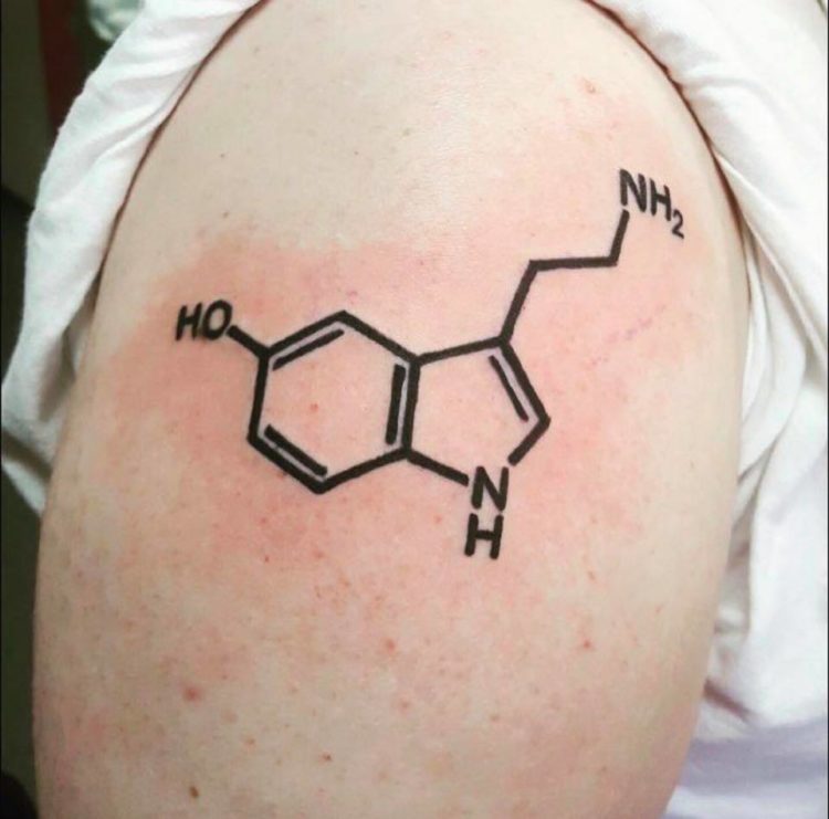 A man with a tattoo of a serotonin molecule on his upper arm