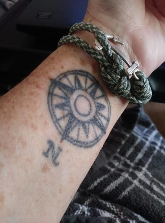 A woman with a tattoo compassed on her wrist