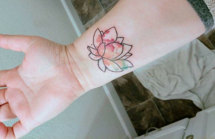 A woman with a lotus flower tattoo on her wrist