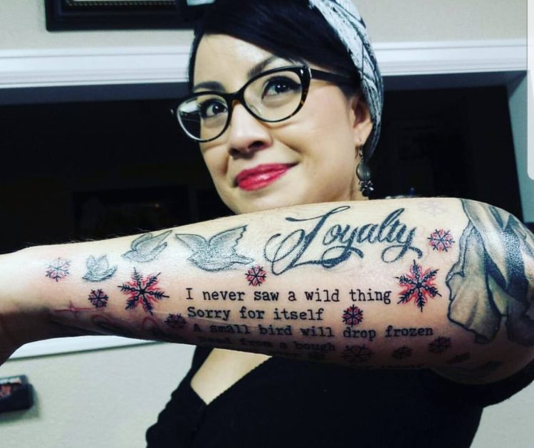 tattoo on woman's arm that is text and different shapes