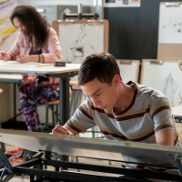 Atypical's Sam bent over a desk working