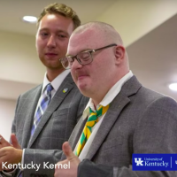 Screenshot of Brack Duncan and Josh Banks at Banks initiation. They are both wearing suits and Banks is giving a thumbs up.