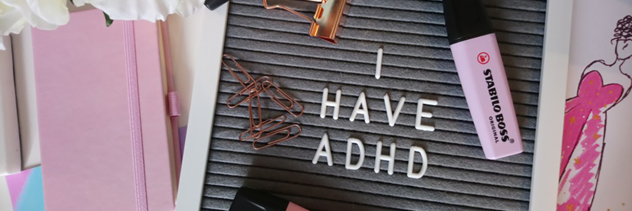 Not Everyone With ADHD Fits the Stereotypes Sign that says "I have ADHD" surrounded by office supplies.
