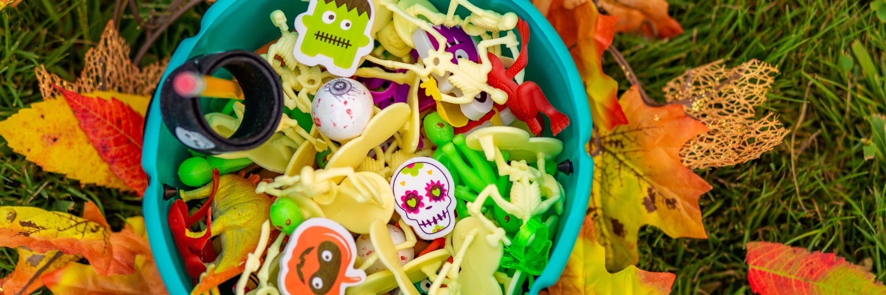 Trick-or-Treating Alternatives for Food Allergy Families on Halloween Teal pumpkin full of halloween toys for a food alternative for kids with food allergies.