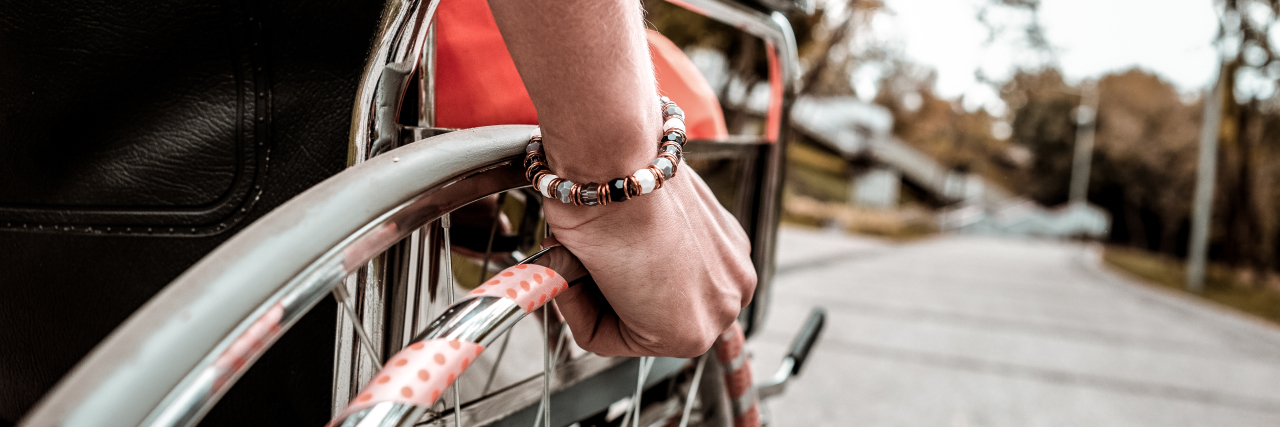 Respect the Bodily Integrity of Disabled People Young woman pushing manual wheelchair.