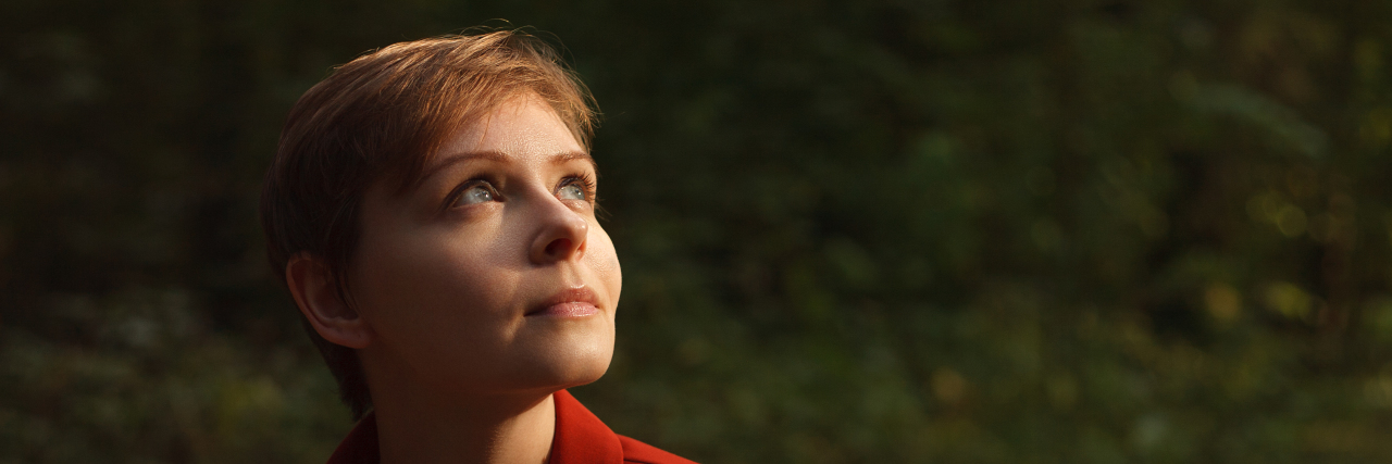 Feeling Guilty About My Cerebral Palsy: What to Do on Bad Days Portrait of a young woman looking up at the light on a green background