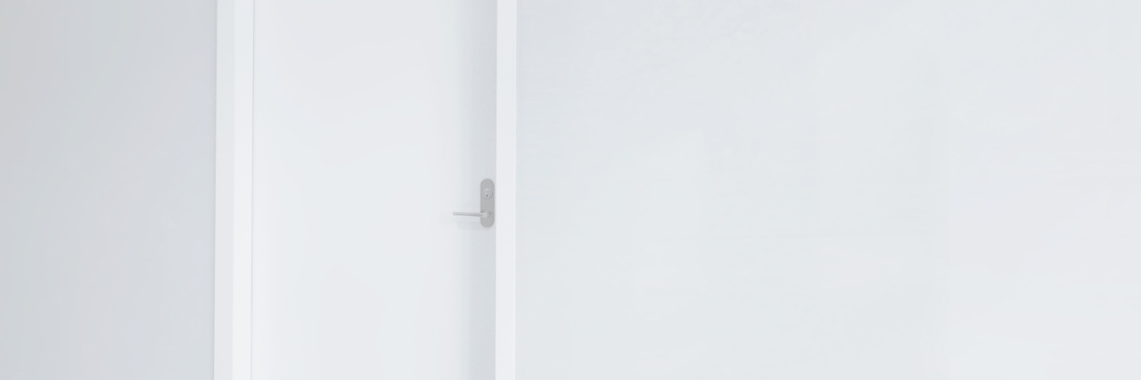 The Dangers Isolation Rooms Pose to Autistic Kids in School white door and blank wall