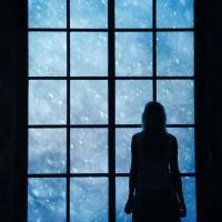 Lonely women standing and looking at lovely snowfall through big closed glass window