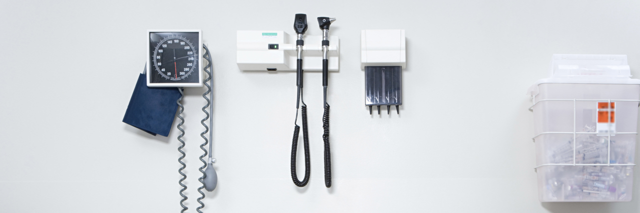 KHN: Trump Rollback Of Disability Rules Make Doctor Visits Painstaking Bed and equipment on the wall of doctor's office.