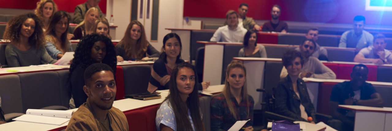 Creating Accessible Events for People With Disabilities Woman lecturing students in lecture theatre, focus midground