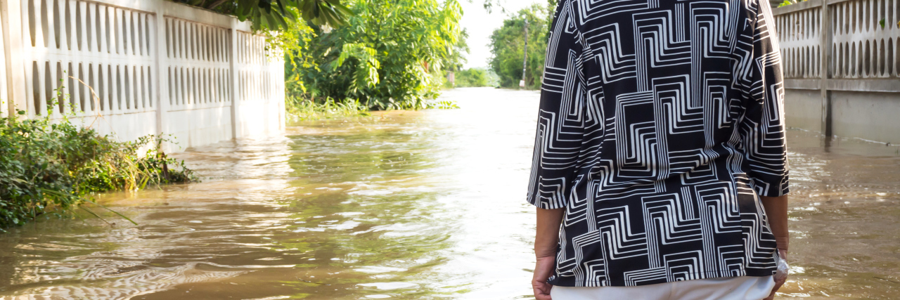 Receiving a Common Variable Immunodeficiency Diagnosis Woman wading in flooding water, focus on legs and back.
