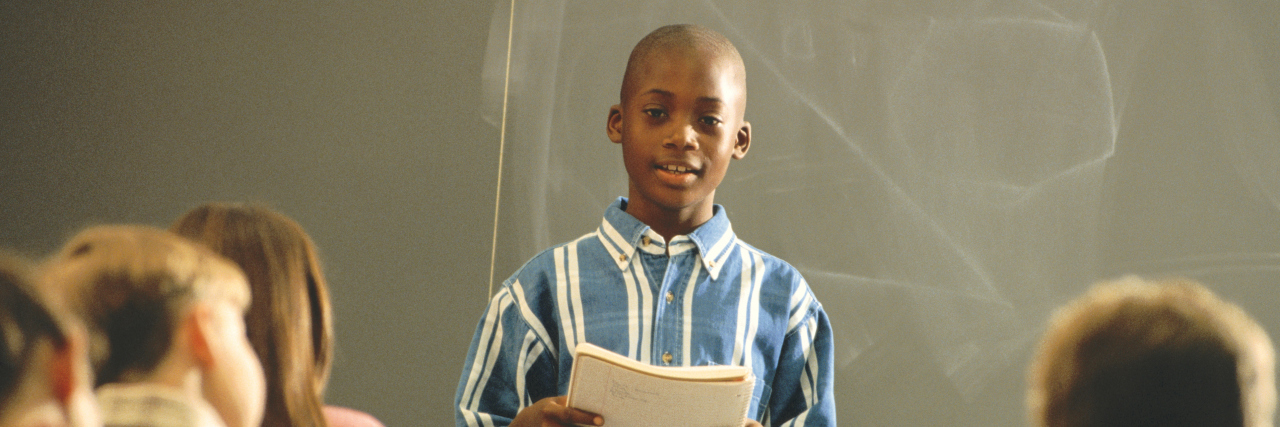 Don't Force Students to Do In-Class Presentations Student reading report in front of class.