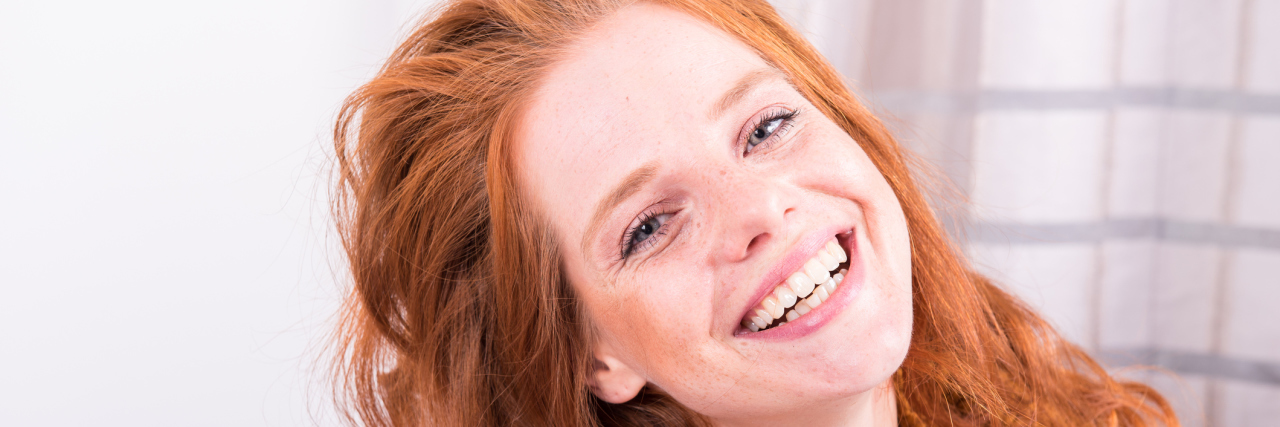 A picture of a red headed woman smiling.