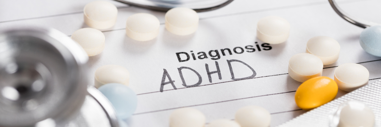 Glasses, pills and a stethoscope with an ADHD diagnosis
