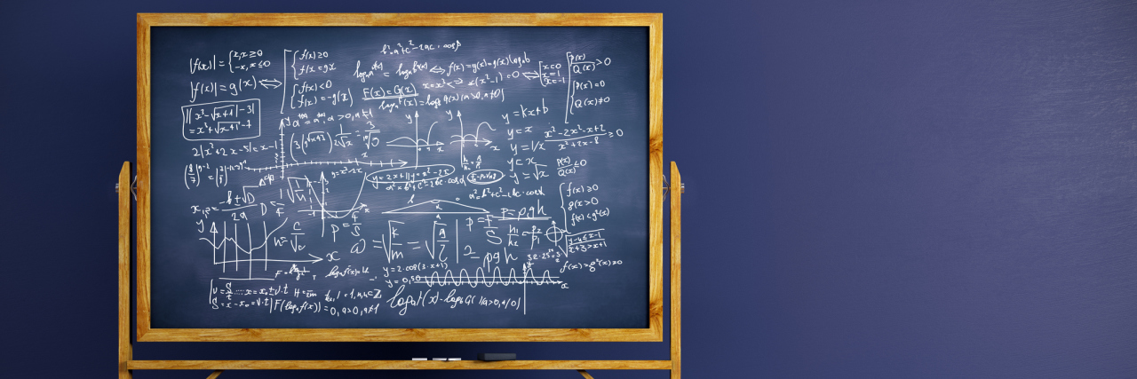 Chalkboard with mathematical formulas placed in interior with blue wall and wooden floor
