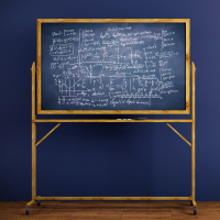 Chalkboard with mathematical formulas placed in interior with blue wall and wooden floor