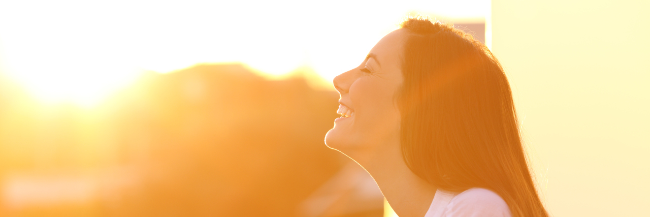 Bringing Awareness to Cerebral Palsy Woman looking towards the sun and smiling.