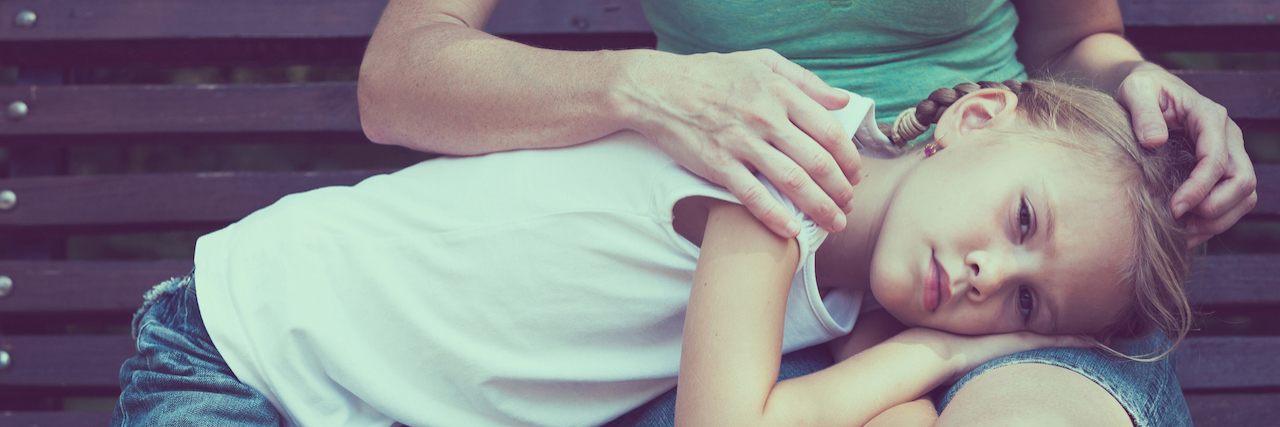 How to Explain Domestic Abuse to Your Children A young girl lying across her mother's lap