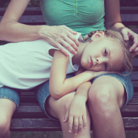 A young girl lying across her mother's lap
