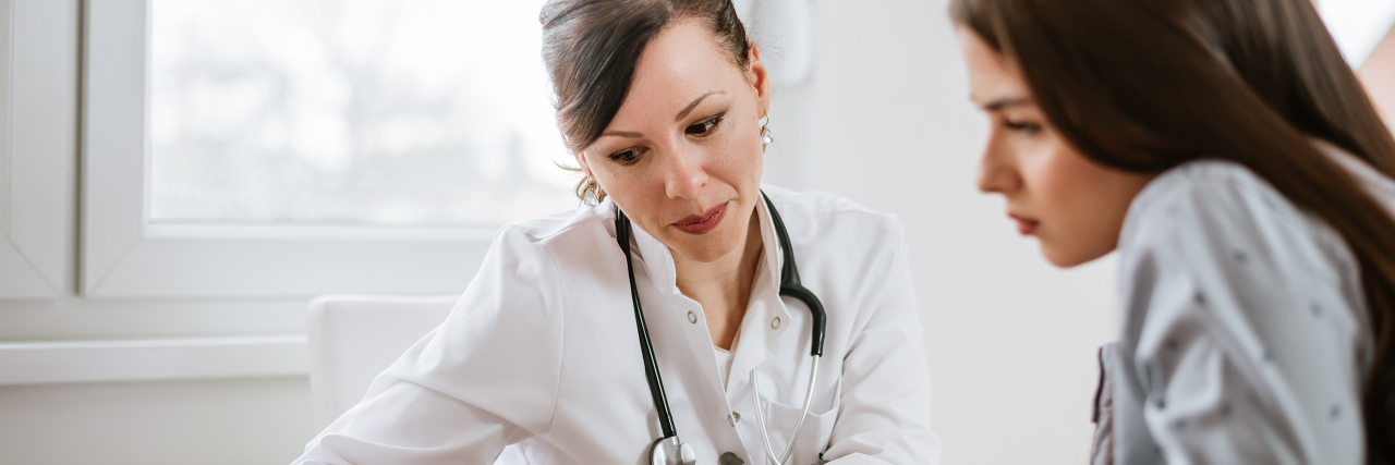 What Information You Should Always Bring to Doctor Appointments female doctor and female patient looking over a piece of paper