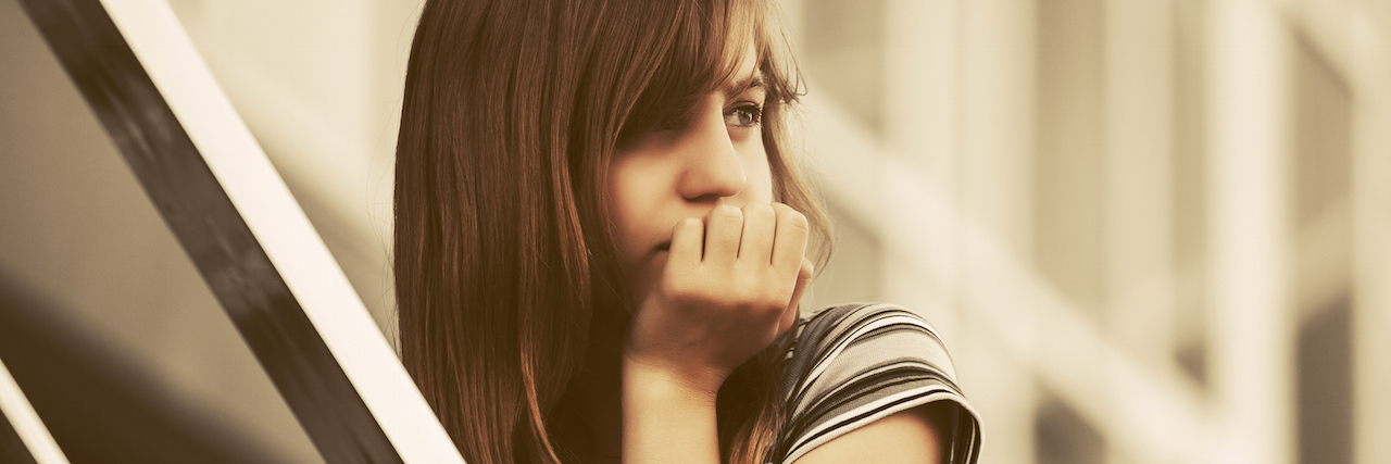 A Letter to My Friend Who Died by Suicide A teen who looks sad walking up the stairs, looking behind her