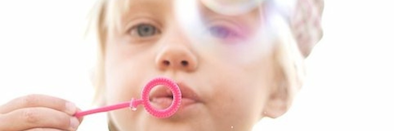 Little girl blowing bubbles