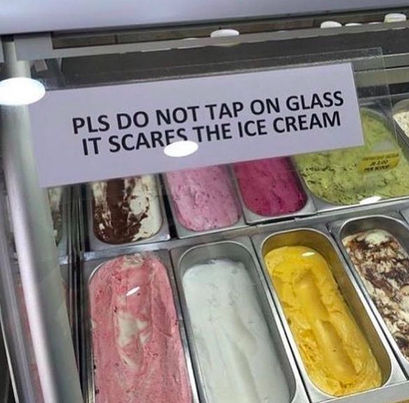 Image of ice cream with sign taped on glass that says "pls do not tap on glass it scares the ice cream'