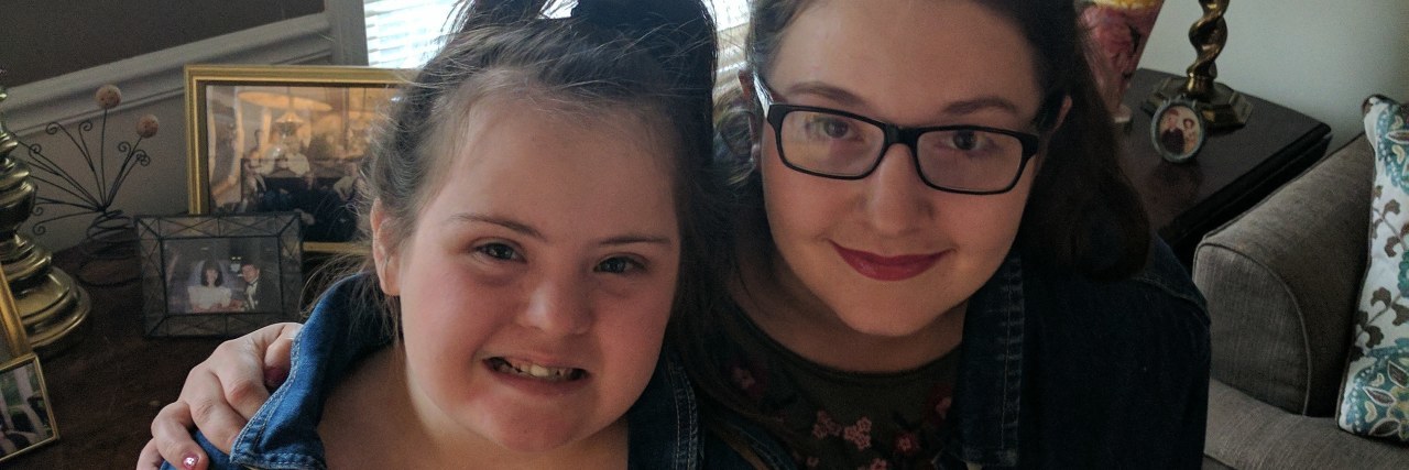 What Having a Sister With Down Syndrome Is Like for Me Sisters posing for camera, smiling, they look alike.