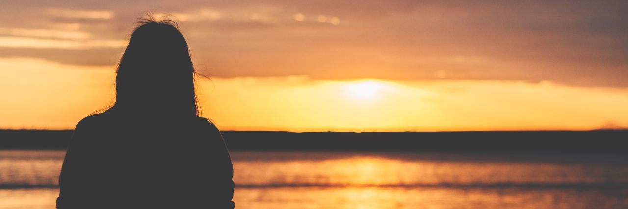 3 Situations That Cause Anxiety and Depression for the Chronically Ill silhouette of a woman watching the sun set over the ocean