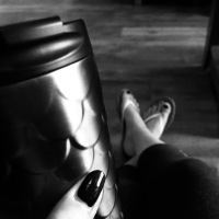black and white photo of a woman holding her coffee cup in the waiting room of a spa