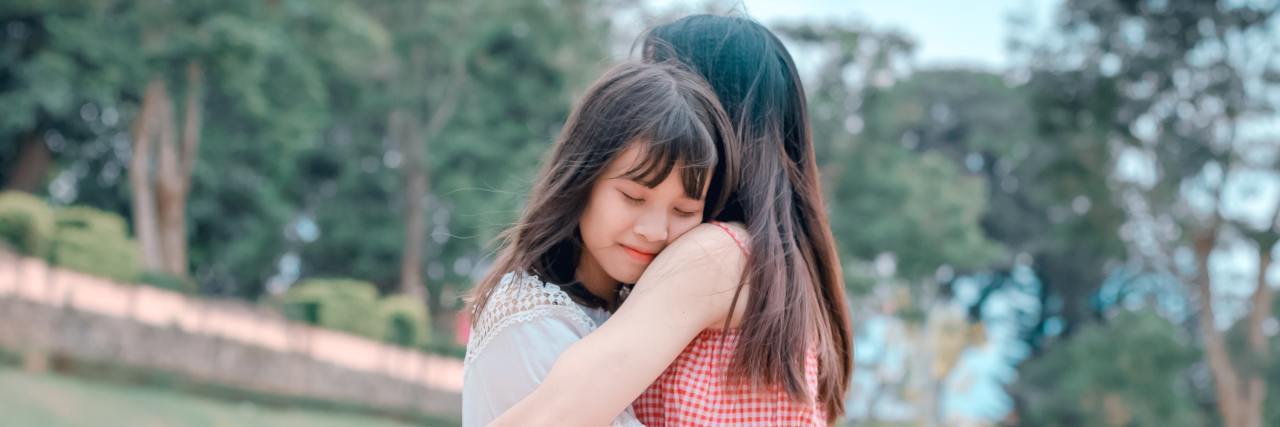 mom and daughter hugging in garden