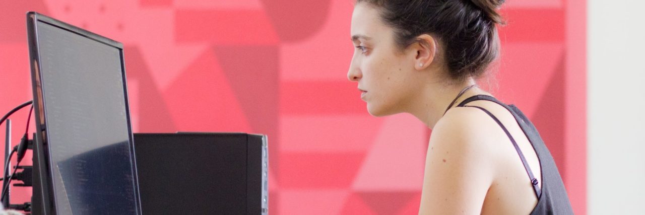 When Bipolar Disorder Makes You Change Jobs Woman working in office with red wall behind her