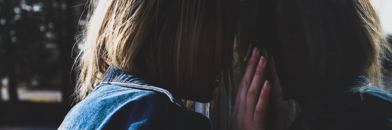 The Frustration of Being Chronically Ill and Undiagnosed woman leaning against a wall and pressing her forehead to it
