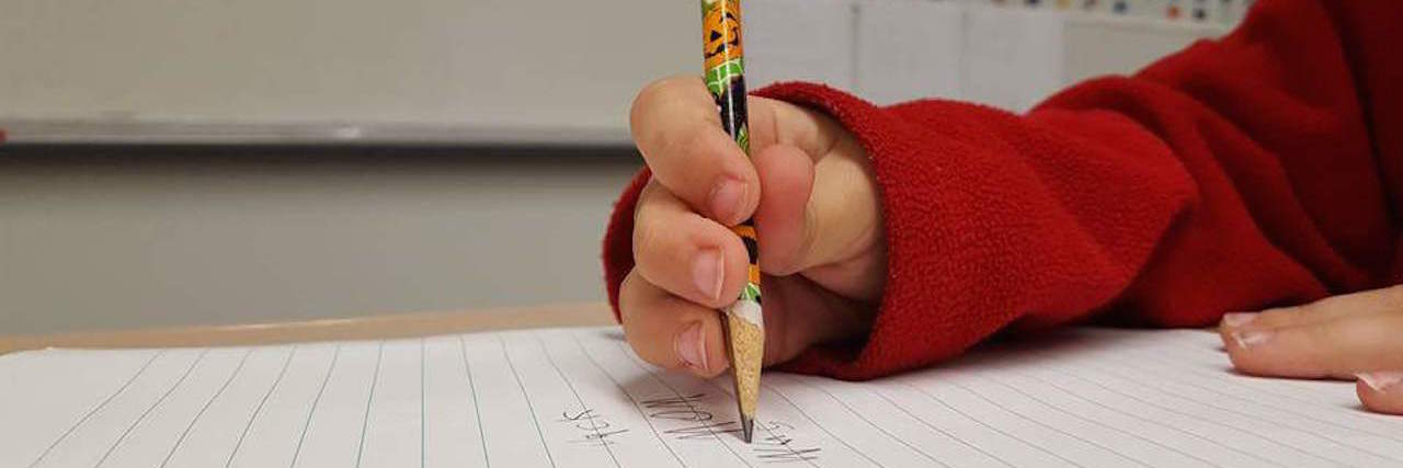 What to Know If Your Kids or Spouse Have Ehlers-Danlos Syndrome kid holding pencil with thumb hyperextended