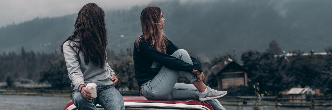 Simple (But Powerful) Ways to Help Someone With Depression two young women sitting on roof of car by mountains