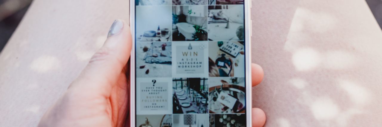 What It's Like Being a Social Media Influencer with Chronic Illness woman holding her phone and scrolling through instagram