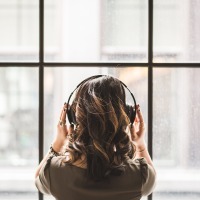 woman wearing headphones looking out of high windows