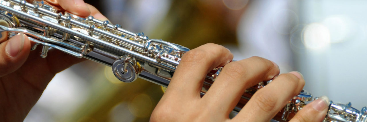 Undiagnosed ADHD in Women Woman's hands playing flute.