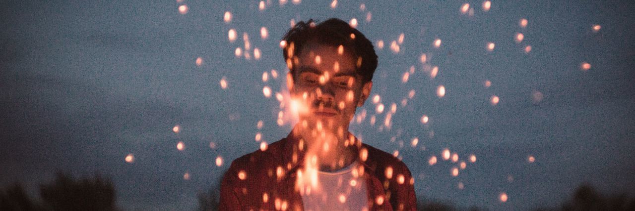 Experiencing a Breakup Because of Bipolar Disorder and Alcohol man standing in front of sparks from fire at night