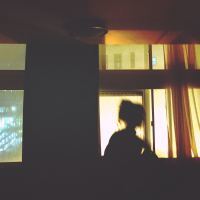blurred photo of woman silhouetted at window