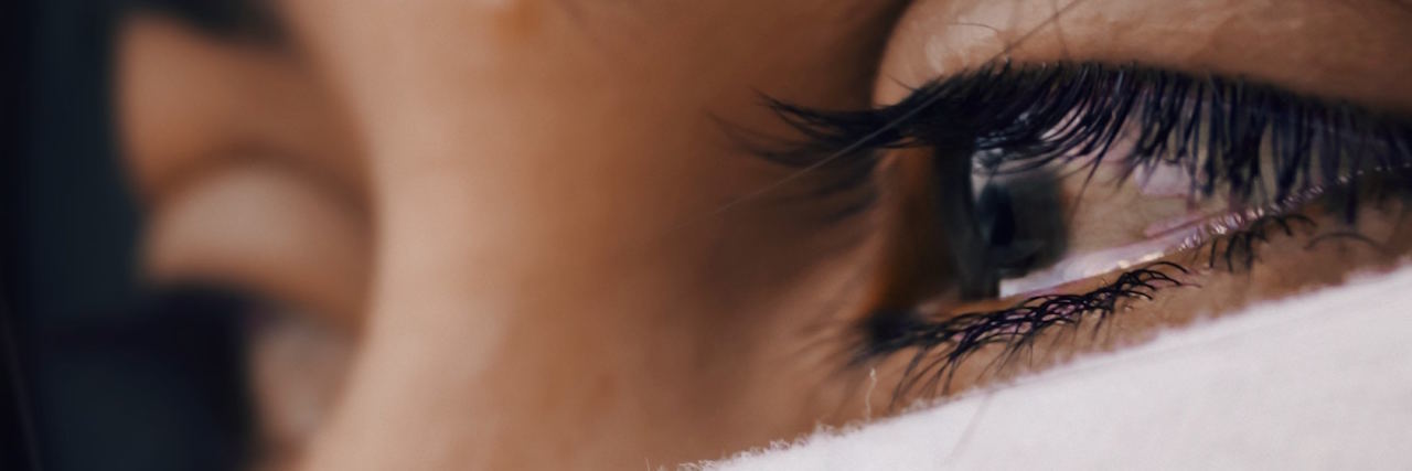 How to Tell a Friend About Bad Mental Health Days A woman with tears in her eyes