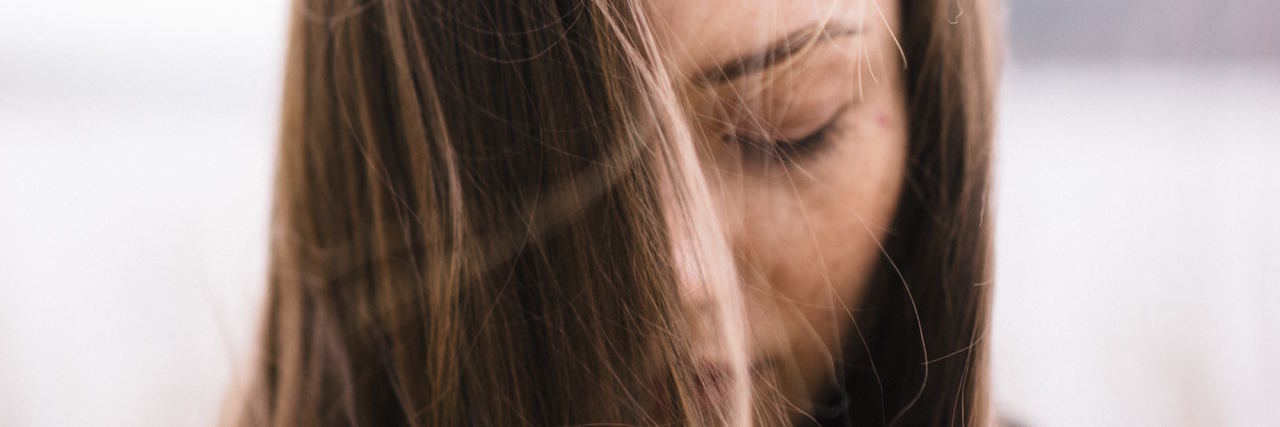 Self-Harm Isn't Just Hurting Yourself Physically woman with long brown hair looking down