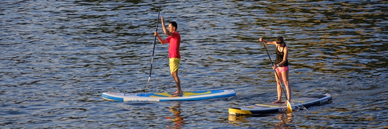 I Have a Mixed Relationship With Cancer Awareness Campaigns A man and a woman on a paddle board.
