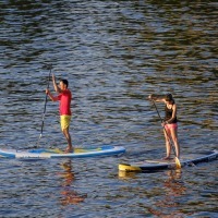 A man and a woman on a paddle board.