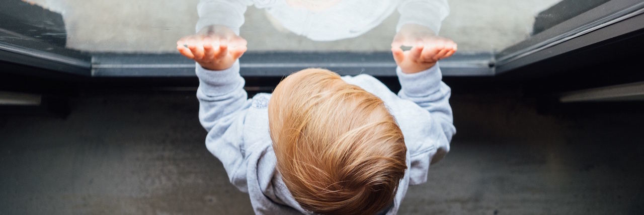 How My Bipolar Disorder Affects My Children A young boy looking at a window, his hands on the glass