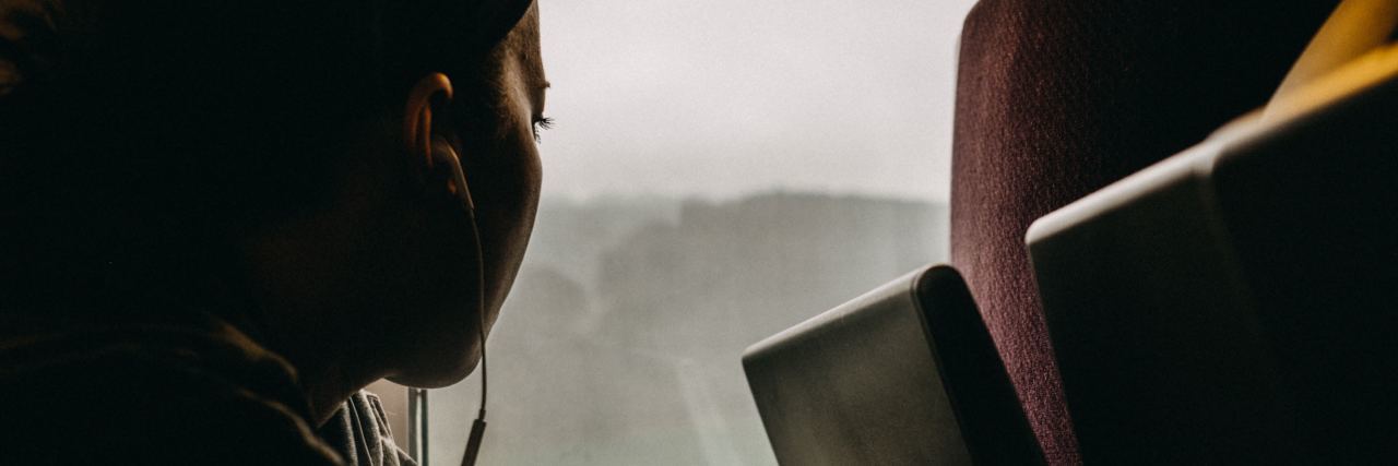 close up of young woman sitting on bus looking out of window