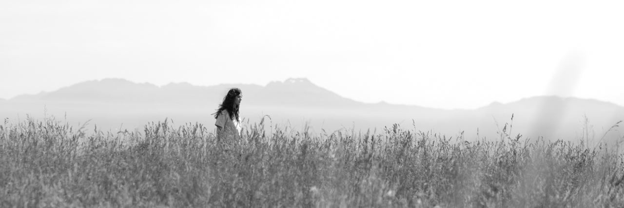 When You Struggle to Reach Out for Help With Suicidal Thoughts black and white photo of woman standing in field with long grass
